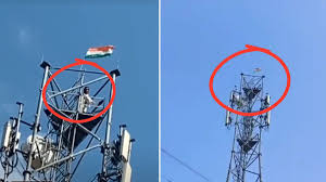 अशोकनगर में मोबाइल टावर पर चढ़े युवक और नीचे खड़ी पुलिस व भीड़ की तस्वीर।