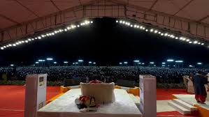 राजकोट में बागेश्वर धाम के धीरेंद्र कृष्ण शास्त्री के दिव्य दरबार में मोबाइल टॉर्च जलाकर डिजिटल आरती करते हजारों श्रद्धालु।