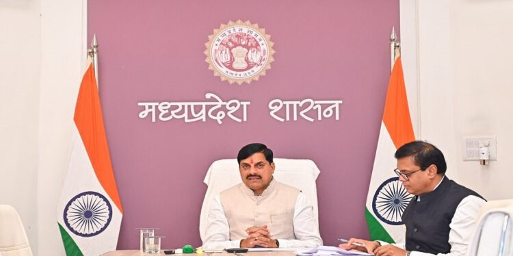 मुख्यमंत्री डॉ. मोहन यादव की उपस्थिति में एग्रीवोल्टाइक प्रोजेक्ट के एमओयू (MoU) की फाइलों का आदान-प्रदान करते अधिकारी और पृष्ठभूमि में सोलर पैनल के नीचे लहलहाती फसल का प्रतीकात्मक कोलाज।