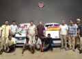 पुलिस थाने के बाहर कतार में खड़ी जब्त की गई स्कॉर्पियो, फॉर्च्यूनर और थार जैसी महंगी लग्जरी कारें और मामले की जांच करते पुलिस अधिकारी।