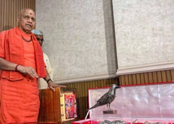 अयोध्या के राम मंदिर ट्रस्ट कार्यालय में कड़े सुरक्षा घेरे के बीच मेज पर सजी सोने की रामचरितमानस, स्वर्ण हार और चरण पादुकाओं को दिखाते ट्रस्ट के पदाधिकारी।