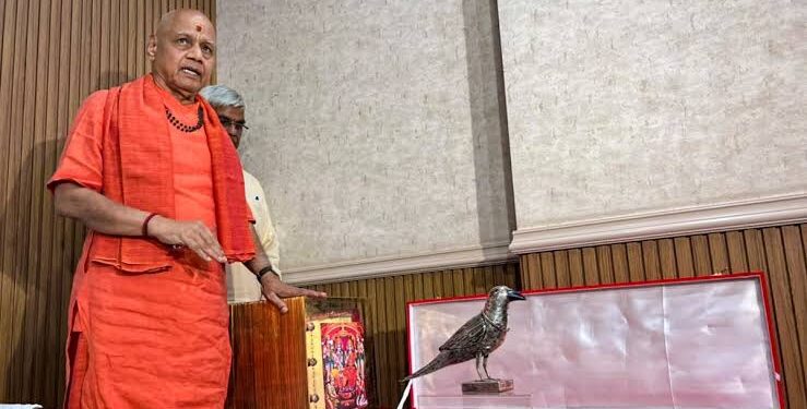 अयोध्या के राम मंदिर ट्रस्ट कार्यालय में कड़े सुरक्षा घेरे के बीच मेज पर सजी सोने की रामचरितमानस, स्वर्ण हार और चरण पादुकाओं को दिखाते ट्रस्ट के पदाधिकारी।