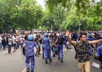 नई दिल्ली में संसद मार्ग के पास पुलिस बैरिकेडिंग और सुरक्षा में तैनात जवानों के साथ गृह मंत्रालय (MHA) के लोगो की प्रतीकात्मक तस्वीर।