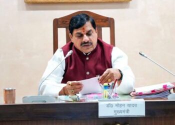 आधी रात के समय रोशनी से जगमगाता भोपाल स्थित मध्य प्रदेश मंत्रालय (वल्लभ भवन) का मुख्य प्रशासनिक परिसर और टेबल पर रखी फाइलों का ढेर।