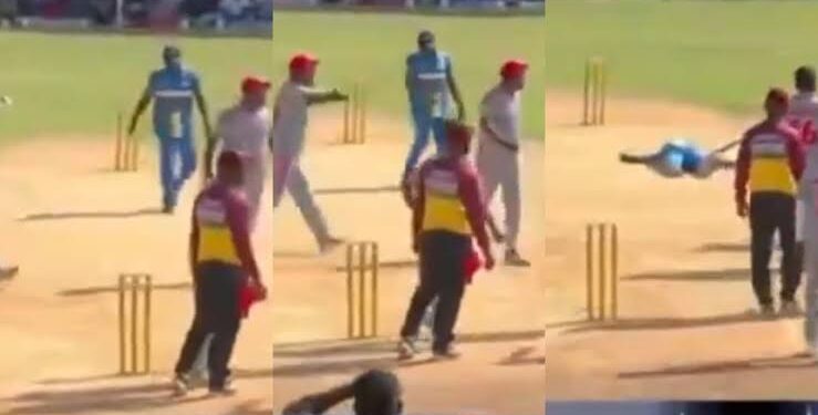 क्रिकेट पिच पर बिखरे हुए स्टंप्स, दस्ताने और हेलमेट के साथ पृष्ठभूमि में उदास बैठे खिलाड़ियों की प्रतीकात्मक धुंधली तस्वीर।