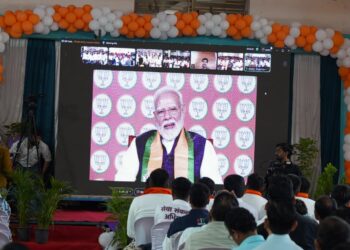 हरदा की माहेश्वरी धर्मशाला में स्क्रीन के माध्यम से सेवा संकल्प बाइक राइडर्स से वर्चुअल संवाद करते प्रधानमंत्री नरेंद्र मोदी और मंच पर उपस्थित भाजपा प्रदेश अध्यक्ष हेमंत खण्डेलवाल व अन्य नेतागण।