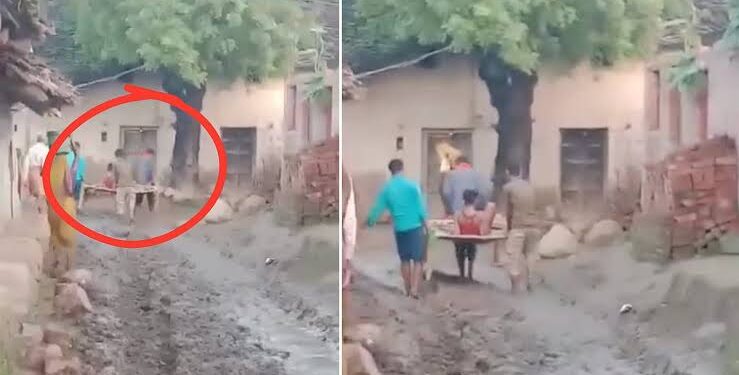 सीधी जिले के ग्रामीण इलाके में कीचड़ भरे रास्ते पर बीमार बुजुर्ग को खाट (चारपाई) पर उठाकर अस्पताल ले जाते ग्रामीण।